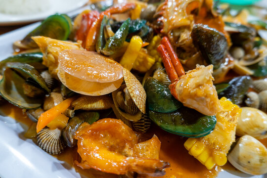 Mixed seafood dish with crab, clams, and shrimp in a spicy sauce