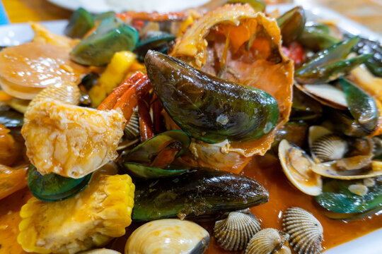 Close up of a savory mixed seafood platter with spicy orange sauce