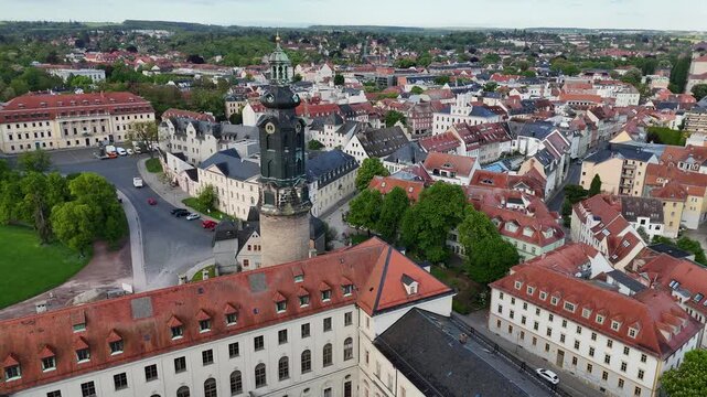 Drone circles tower while revealing rooftops and old town panorama
