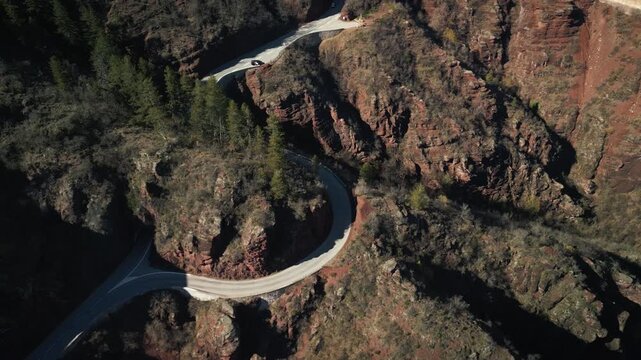 Drone footage of the Gorges de Daluis in France, captured in the sunny evening light. At a narrow point, the road splits into a tunnel and a narrow section running along the rock face.