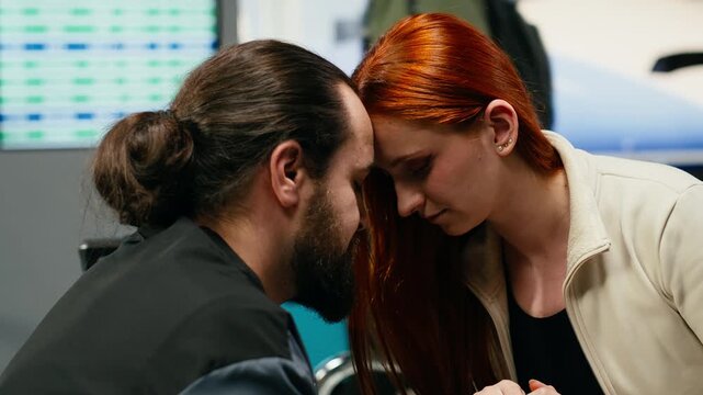 A couple holds hands and shares a romantic moment while waiting for a flight, expressing affection and intimacy during holiday travel together.