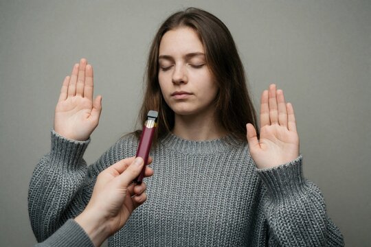 Teenage girl rejects disposable vape with hand gesture. Young woman refuses electronic cigarette offer, choosing health and abstinence from nicotine addiction. No vaping.