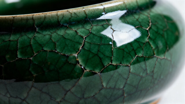 Close-up of dark green crackle glaze on handcrafted ceramic pottery