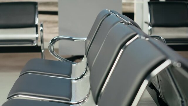 A quiet airport waiting area has no passengers or luggage, with modern chairs and boarding gates inside an empty terminal before departure.