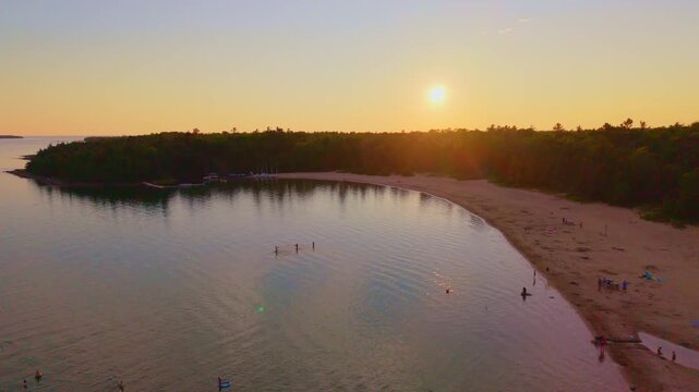 Bruce Penisula, Canada - July 8 2026: A stunning 4K aerial drone view of Singing Sands Beach in the Bruce Peninsula, showcasing shallow turquoise waters, soft sandy shores, and lush coastal forests.