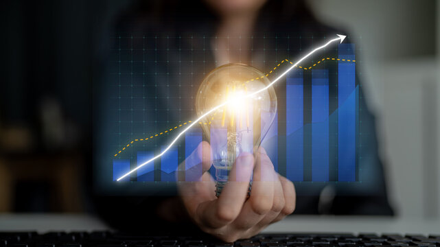 A person holds a glowing light bulb, symbolizing innovation, while a dynamic upward trend graph illustrates business growth and success in a digital landscape. Impute