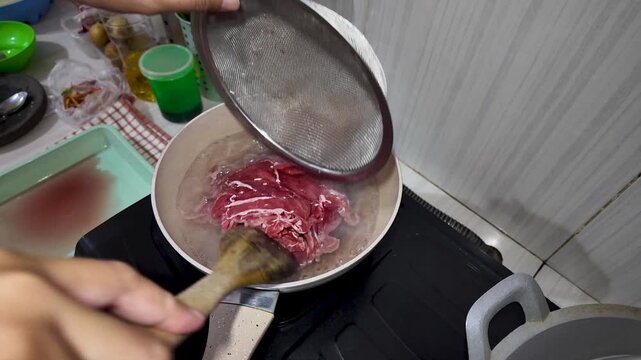 Pouring Raw Meat into Boiling Water for Cooking