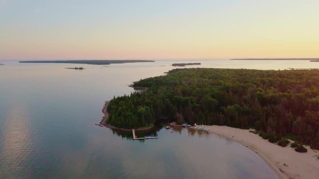 Bruce Penisula, Canada - July 8 2026: A stunning 4K aerial drone view of Singing Sands Beach in the Bruce Peninsula, showcasing shallow turquoise waters, soft sandy shores, and lush coastal forests.