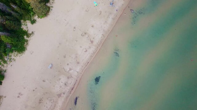 Bruce Penisula, Canada - July 8 2026: A stunning 4K aerial drone view of Singing Sands Beach in the Bruce Peninsula, showcasing shallow turquoise waters, soft sandy shores, and lush coastal forests.