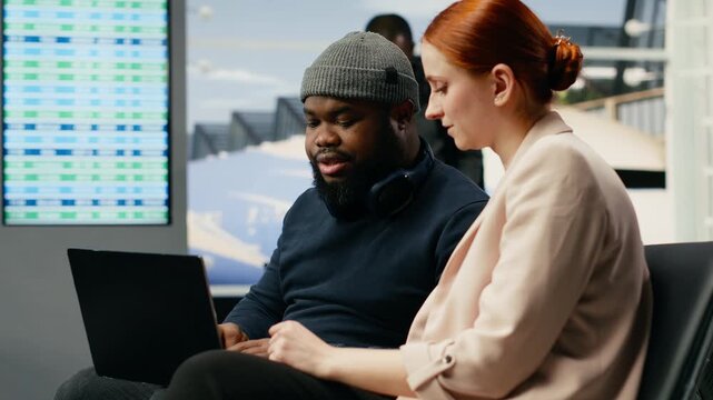Diverse business colleagues prepare in an airport lounge for a meeting abroad, traveling as a delegation to a multinational company event at headquarters.