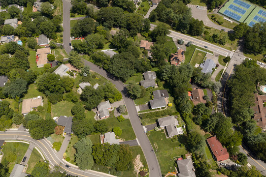 Aerial drone view of tree-lined residential neighborhood with detached homes and local streets in Bayberry Park, New Rochelle, New York