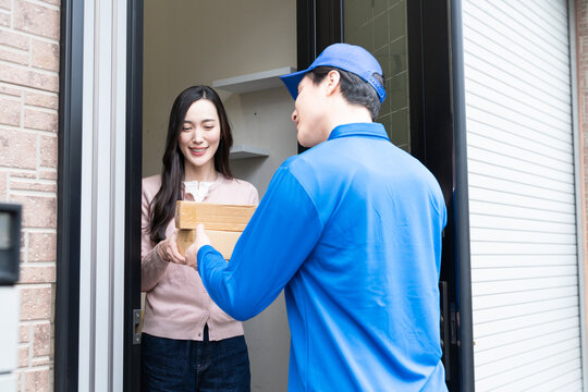 若い女性と宅配業者の荷物の受け渡し　ライフスタイルイメージ