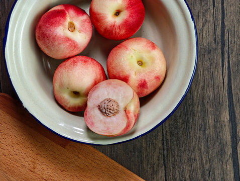 Red apple pink peach fruit whole sliced half seed tin plate chopping board wooded background