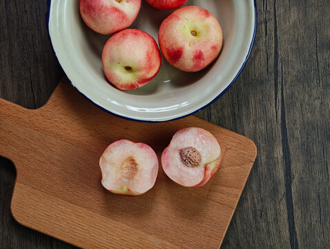 Red apple pink peach fruit whole sliced half seed tin plate chopping board wooded background