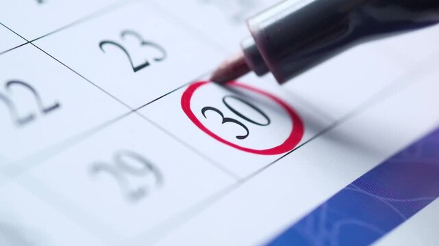 Marker circling day 30 on calendar marking important date reminder close up footage