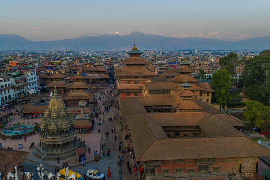 Lalitpur, Nepal - 14 November 2025: Aerial view of Patan Darbar Square featuring historic pagoda temples, intricate brick architecture, and bustling courtyards under a clear sky.