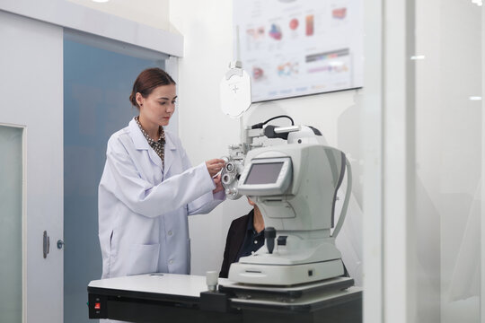 Female patient eye exam with refractometer device, vision and eyesight improvement by expert optometrist woman, diagnostic for eyeglasses lens, professional technology services in optical clinic.