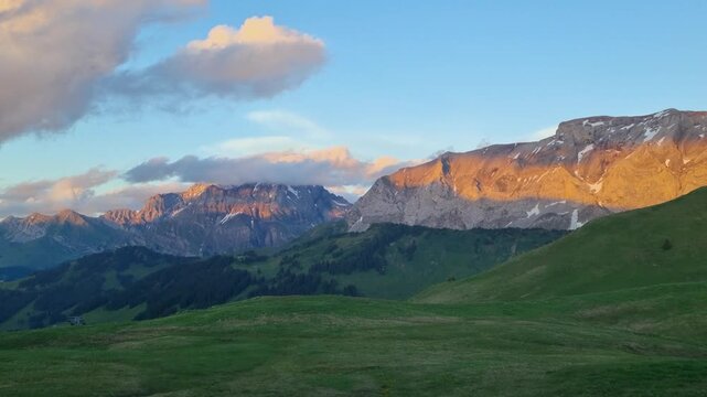 Golden sunset illuminates the alpine peaks around Hahnenmoos Pass in Bern, Switzerland. Peaceful summer meadows, dramatic mountain scenery, and a tranquil atmosphere create a meditative andscape