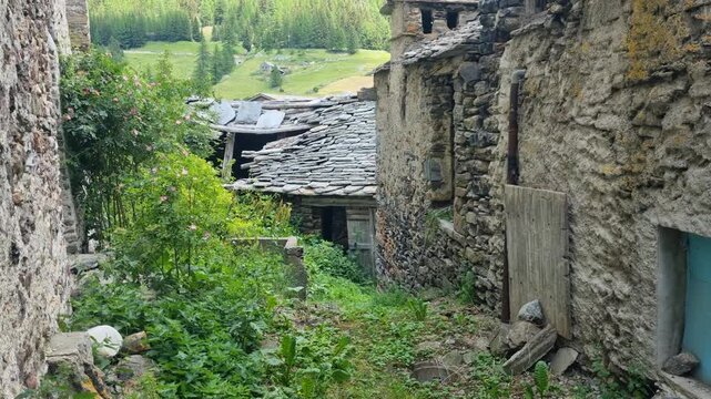 Deserted section of Simplon Dorf, Switzerland, with traditional stone houses gradually falling into disrepair and being reclaimed by vegetation, capturing rural Alpine decay and abandonment