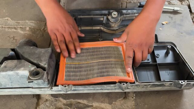 Hands Installing Clean Engine Air Filter Inside Car Air Intake Housing During Repair