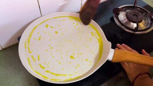 mustered oil Spread On Hot Pan Before Making Traditional Indian Dosa Or Crepe Recipe