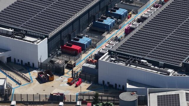 High angle view showcasing a modern data center with extensive solar panel arrays on the roof and large industrial cooling units, highlighting sustainable technology and big data infrastructure