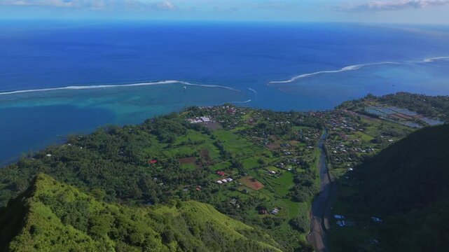 Tara Huhurahi Ridge town of Teahupo'o village South Pacific Ocean Tahiti French Polynesia aerial drone early sunny morning Teahupo'o lagoon surfing Passe Havea coral reef break waves forward pan down