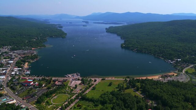 Lake George New York State aerial drone view Town of Lake George Steamboat Company ferry boats landscape summer sunny morning blue sky Adirondack Mountains Million Dollar Beach swim beach forward pan
