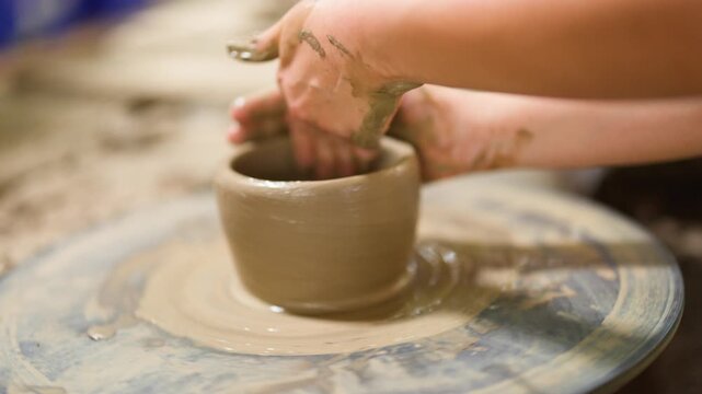 Artisan Hands Shaping Clay Pot on Rotating Pottery Wheel