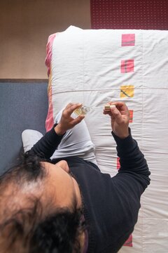 Top view of a man using a glass dropper bottle to apply hair loss treatment