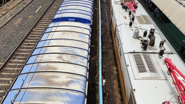 Elevated top view of an electric locomotive showing the pantograph roof insulators and electrical equipment while passing a railway station
