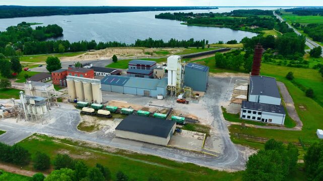 High angle view, aggregate production facility with storage silos beside river