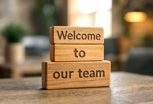 Wooden blocks with welcome to our team message stacked neatly on table in modern office setting