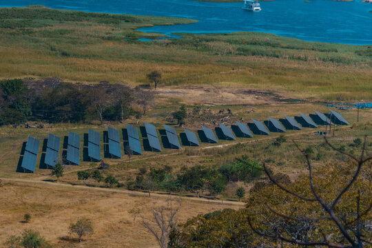 Kafue, Zambia - 19 July 2026: Aerial view of a solar farm with rows of photovoltaic panels situated in a grassy landscape near the Kafue River.