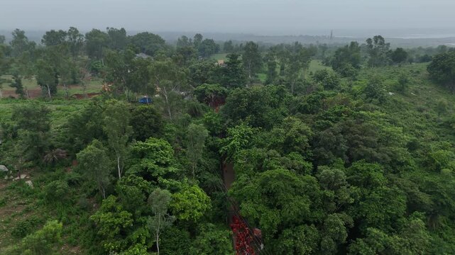 Aerial drone view of Kanwar Yatra pilgrims walking along the sacred route from Sultanganj to Deoghar during Shravan, capturing devotion, crowds, colorful kanwars, and India's largest annual pilgrimage