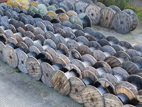 Krakow, Malopolskie, Poland - 18 July 2026: Aerial view of Tele-Fonika Kable S.A. featuring numerous large wooden cable reels stored in an industrial yard.
