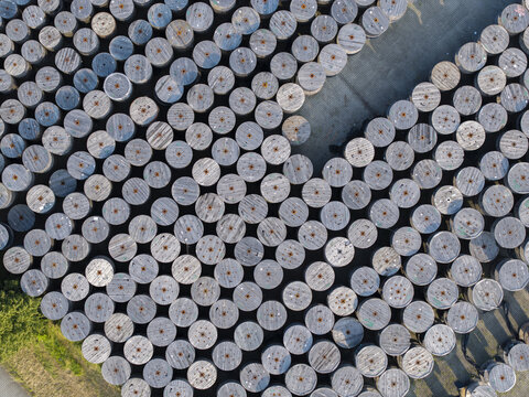 Krakow, Malopolskie Voivodeship, Poland - 18 July 2026: Aerial view of Tele-Fonika Kable SA facility featuring rows of large industrial cable reels stored in an outdoor yard.