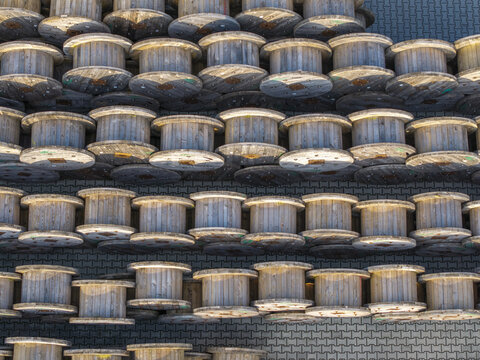 Krakow, Poland - 18 July 2026: Aerial view of wooden cable reels stored at the Tele-Fonika Kable S.A. facility, featuring rows of industrial spools on a paved surface.