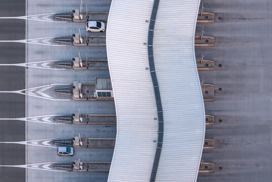 Baillargues, Occitanie, France - 18 July 2026: Aerial view of a highway toll plaza with sweeping architectural lines, directional arrows, and minimal traffic creating a geometric composition.