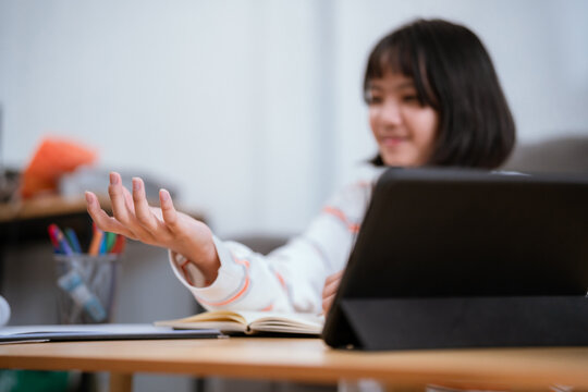 Young person engaged in creative writing with a notebook in a cozy indoor setting during the afternoon