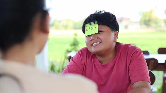 Children play the guessing game "Who am I?", with paper stickers on their foreheads.