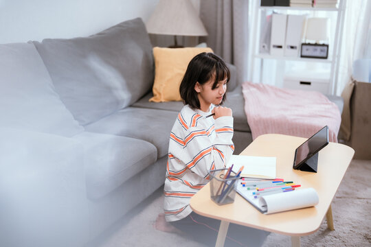 A child sitting and working at home in the morning light.
