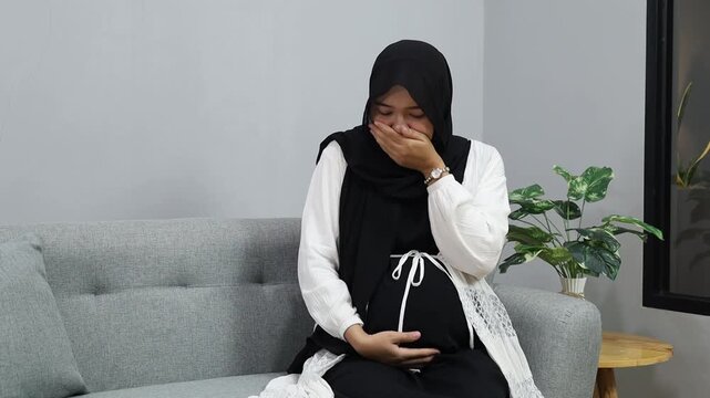 Asian muslim Pregnant woman suffering from nausea at home
