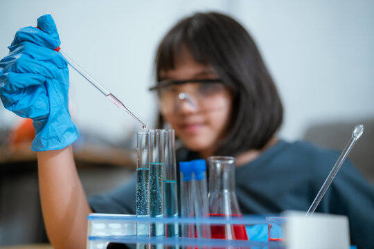 Young girl conducting a science experiment in a laboratory setting during the day