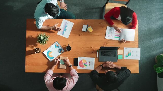 Top down view of business woman explain and present financial chart. Diverse group discuss and listen presentation about stock market statistic at meeting table with investment graph. Convocation.