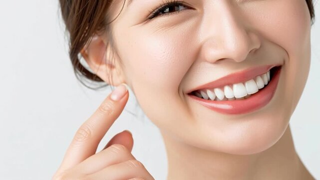 Smiling woman face with white teeth, finger on cheek, dental care and healthy skin, close up beauty portrait on clean background, happy smile