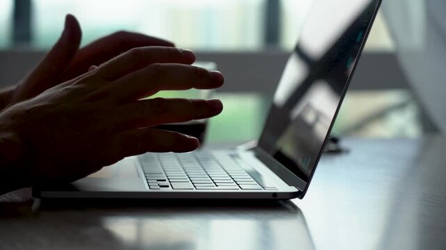 A Focused Moment of Productivity: A Close-Up View of a User Engaged with a Laptop, Highlighting Technology and Concentration in a Bright Workspace