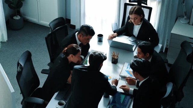 Top view of skilled project manager listen presentation while businessman explains idea and present marketing strategy at meeting table with financial statistic graph placed at boardroom. Directorate.