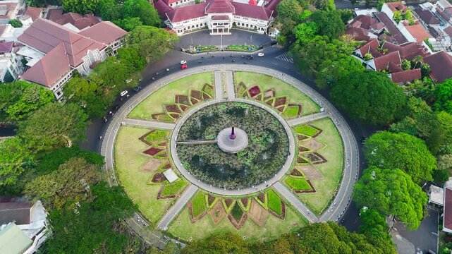 Malang, Indonesia - 27 July 2026: Aerial view of Alun Alun Tugu Malang featuring a central lotus-shaped pond, lush gardens, and surrounding historic colonial architecture.