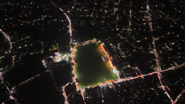 Aerial drone footage of Baba Baidyanath Dham in Deoghar at night, showcasing the illuminated temple complex, glowing city lights, surrounding streets, and the sacred Jyotirlinga pilgrimage site.
